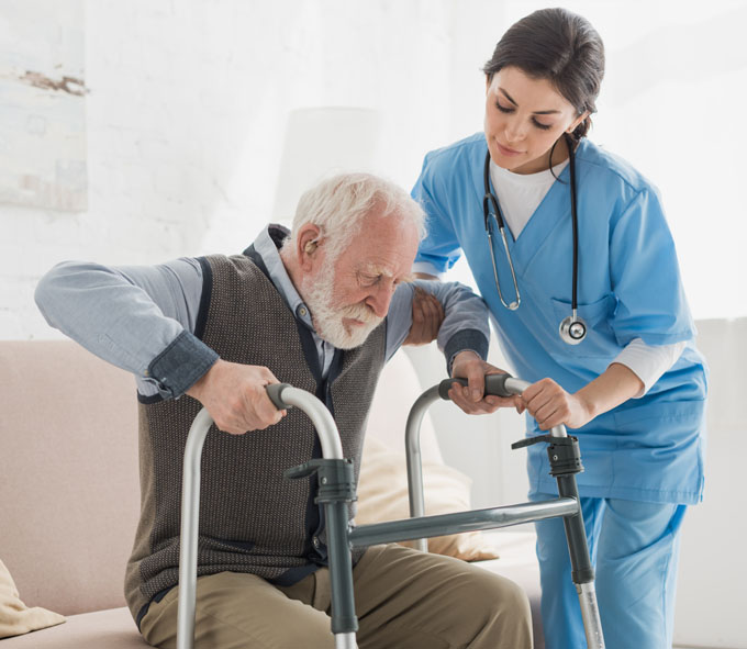 Nurse helping an elderly man with a walker to get up at his home | Specialized Services | Miami FL 33165 | call 305-220-1088