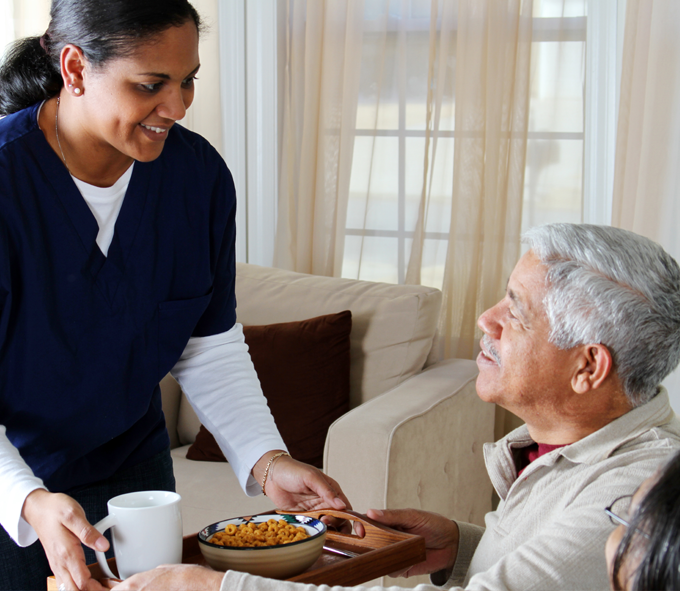 Nurse serving lunch to an elderly man at home | Medicaid Services | Miami FL 33165 | call 305-220-1088